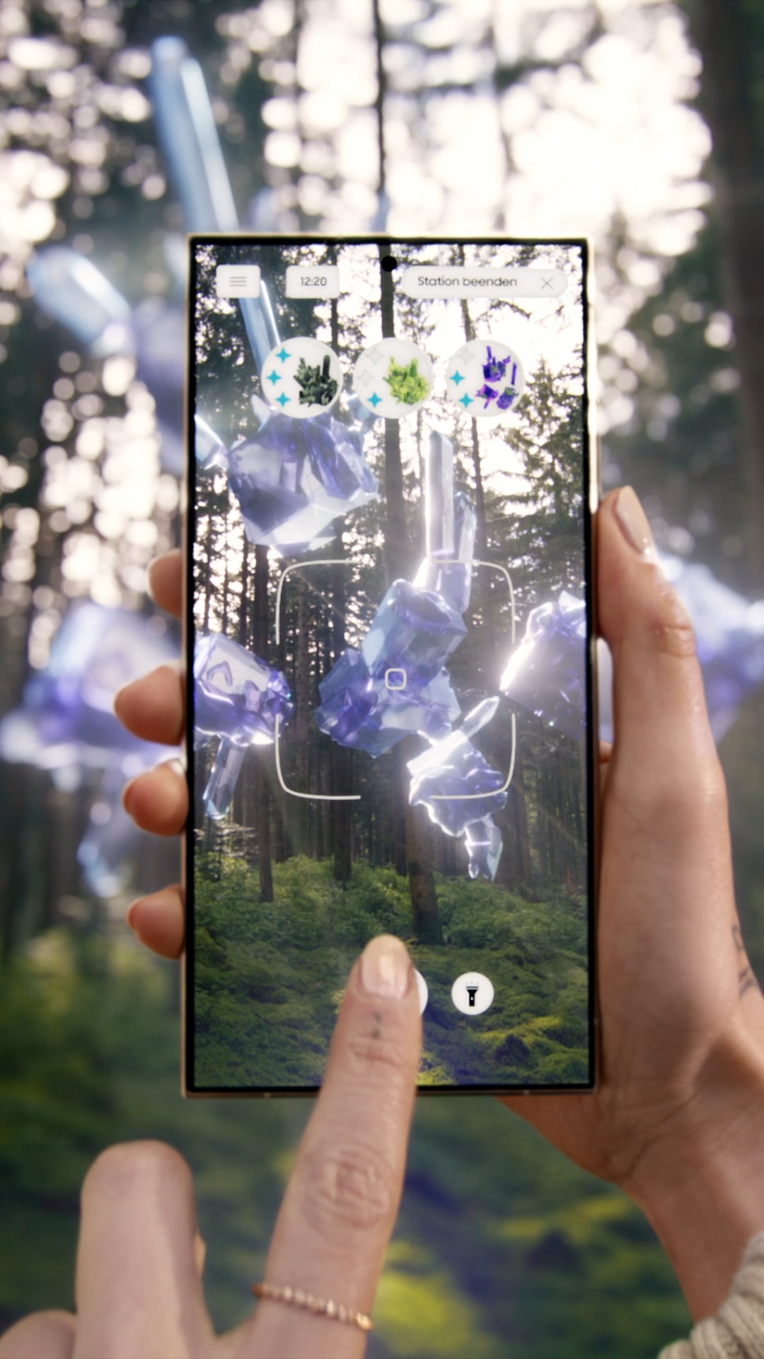 A person's hand holds a smartphone displaying an augmented reality scene with floating crystal formations in a forested area.