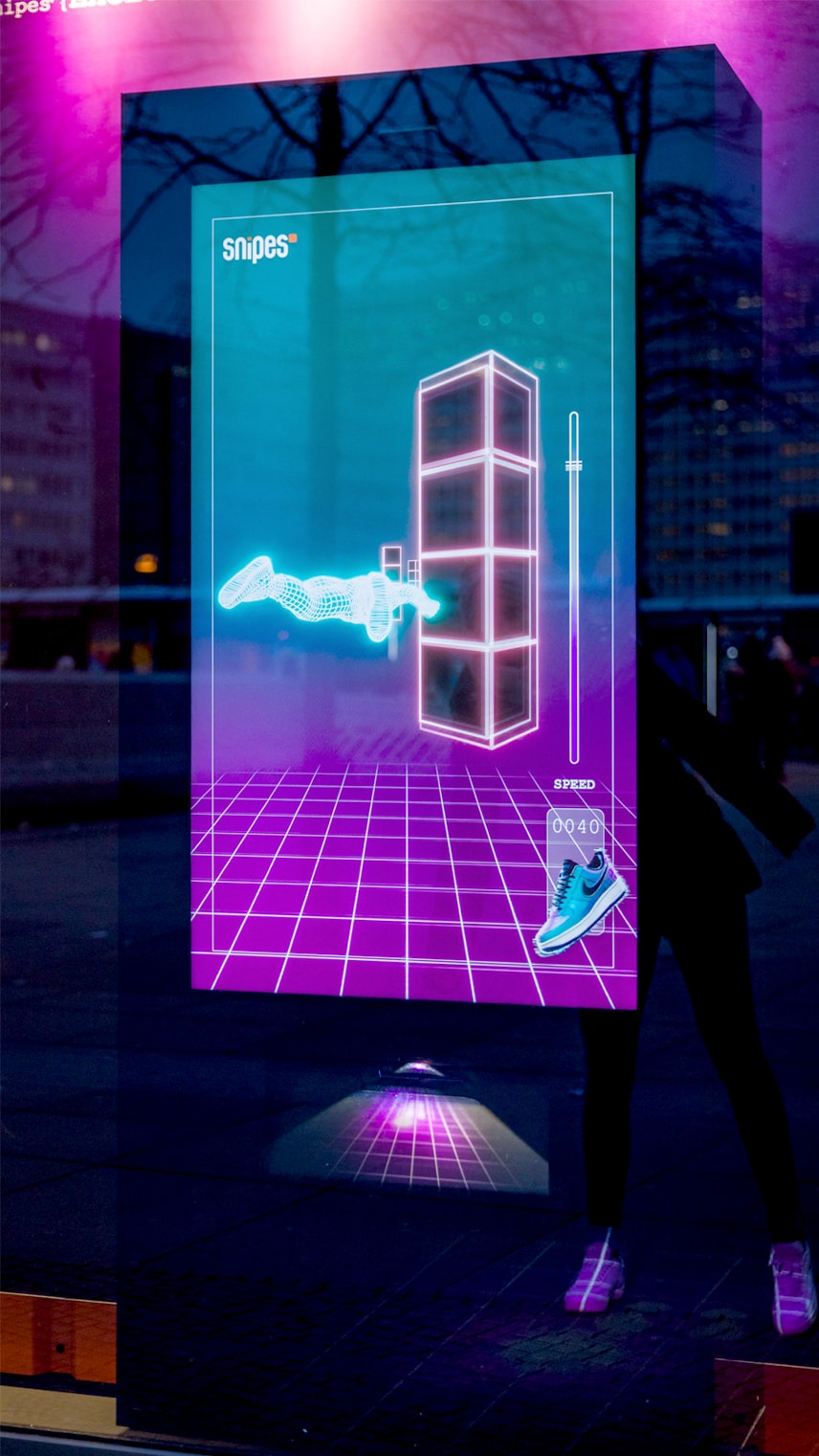 A vibrant digital display showcases a futuristic sneaker design alongside dynamic speed metrics in a neon-lit environment.