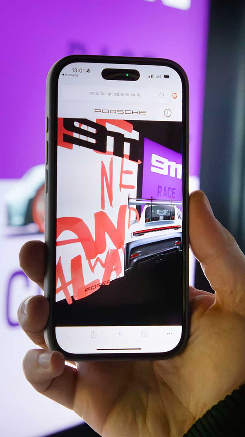 A person interacts with a digital display featuring an animated bubble and vibrant visuals, while wearing headphones.