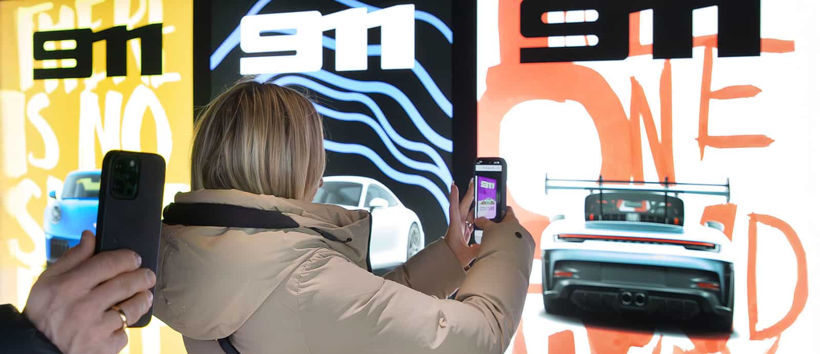 A smartphone displays a Spotify poster featuring a smiling person with a scenic background.